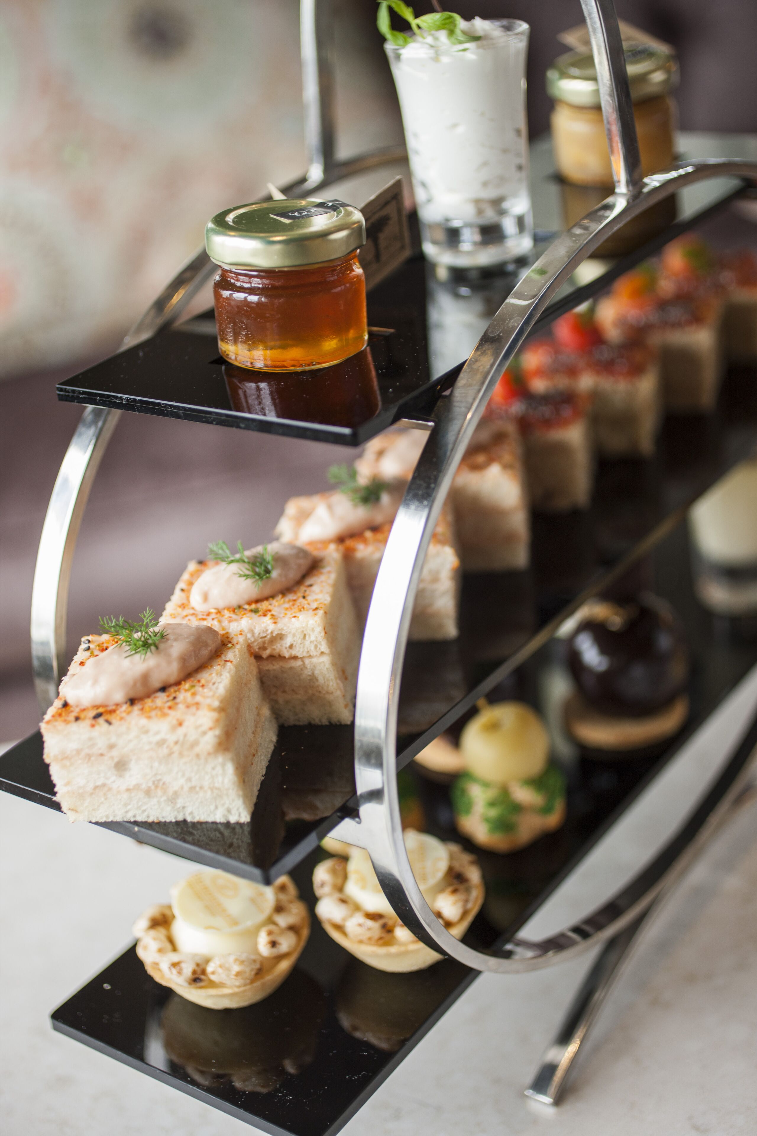 A dessert display with various sweet treats and beverages on a black tray.