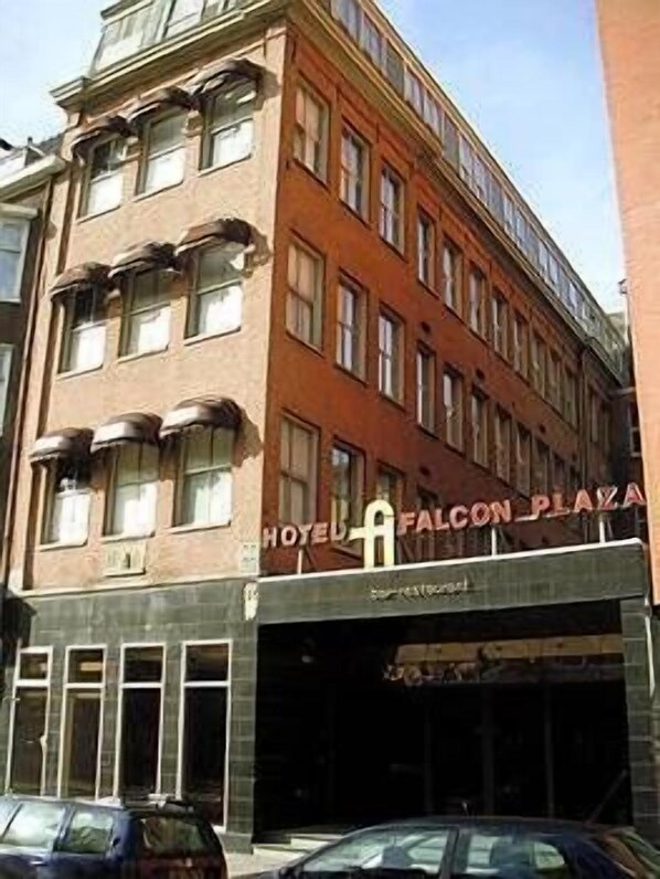 Un hotel de varios pisos con un cartel que dice "Hotel Falcon Plaza".