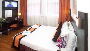 A hotel room with a bed, a desk with a chair, a television, a telephone, and a window with curtains. - Hotel Falcon Plaza (Amsterdam)