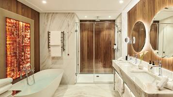 A modern bathroom with a freestanding bathtub, a glass-enclosed shower, and a vanity with a large mirror.