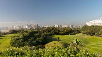 Enjoy a round of golf amidst a lush, green landscape with ocean views.