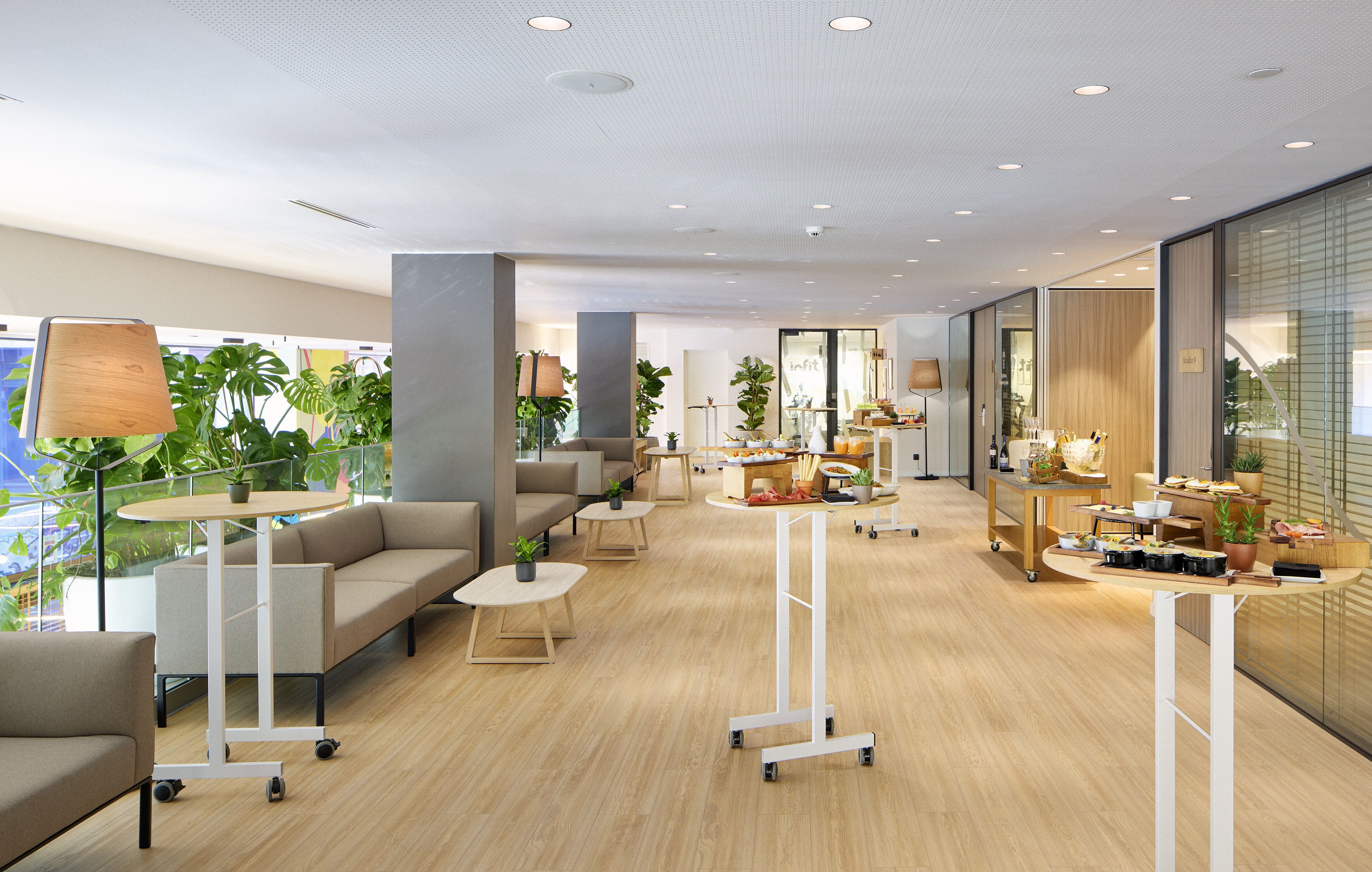 A modern interior with sofas, tables, and potted plants.