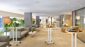 A modern interior with sofas, tables, and potted plants.