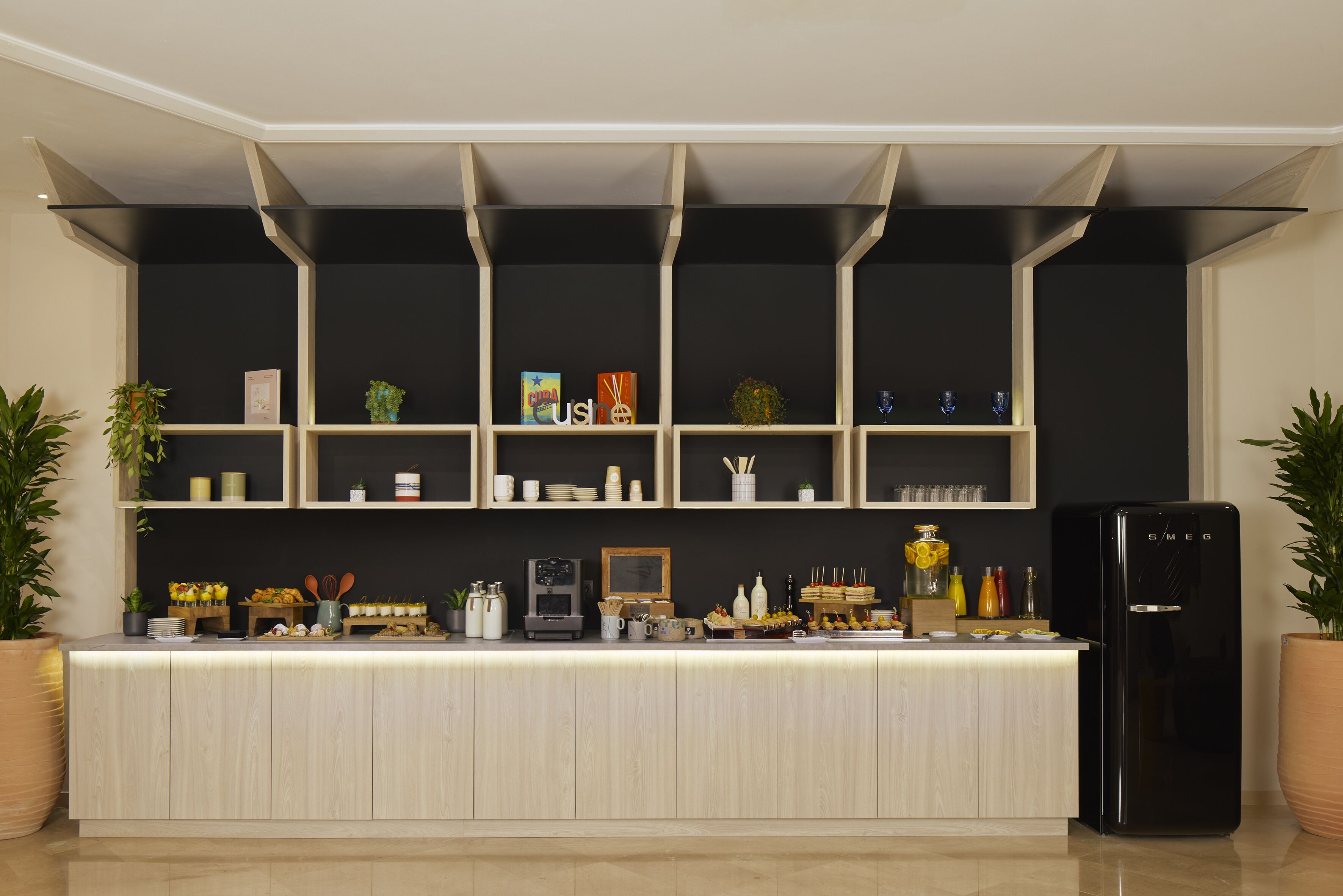 A modern kitchen with a central island, black cabinets, and a black refrigerator.