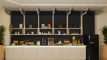 A modern kitchen with a central island, black cabinets, and a black refrigerator.