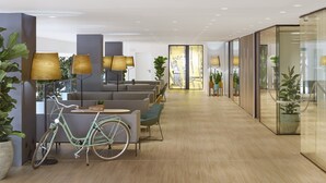 A modern indoor space with a bicycle, seating area, and ambient lighting. - INNSiDE by Melia Barcelona Apolo (Barcelona)