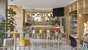 A modern bar area with wooden accents, a variety of seating options, and a visible bar counter with bottles.