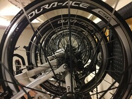 Una rueda de bicicleta con la marca 'DURA-ACE', un cuadro blanco y una cadena.
