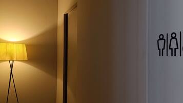 A lamp and a wall with a restroom sign.