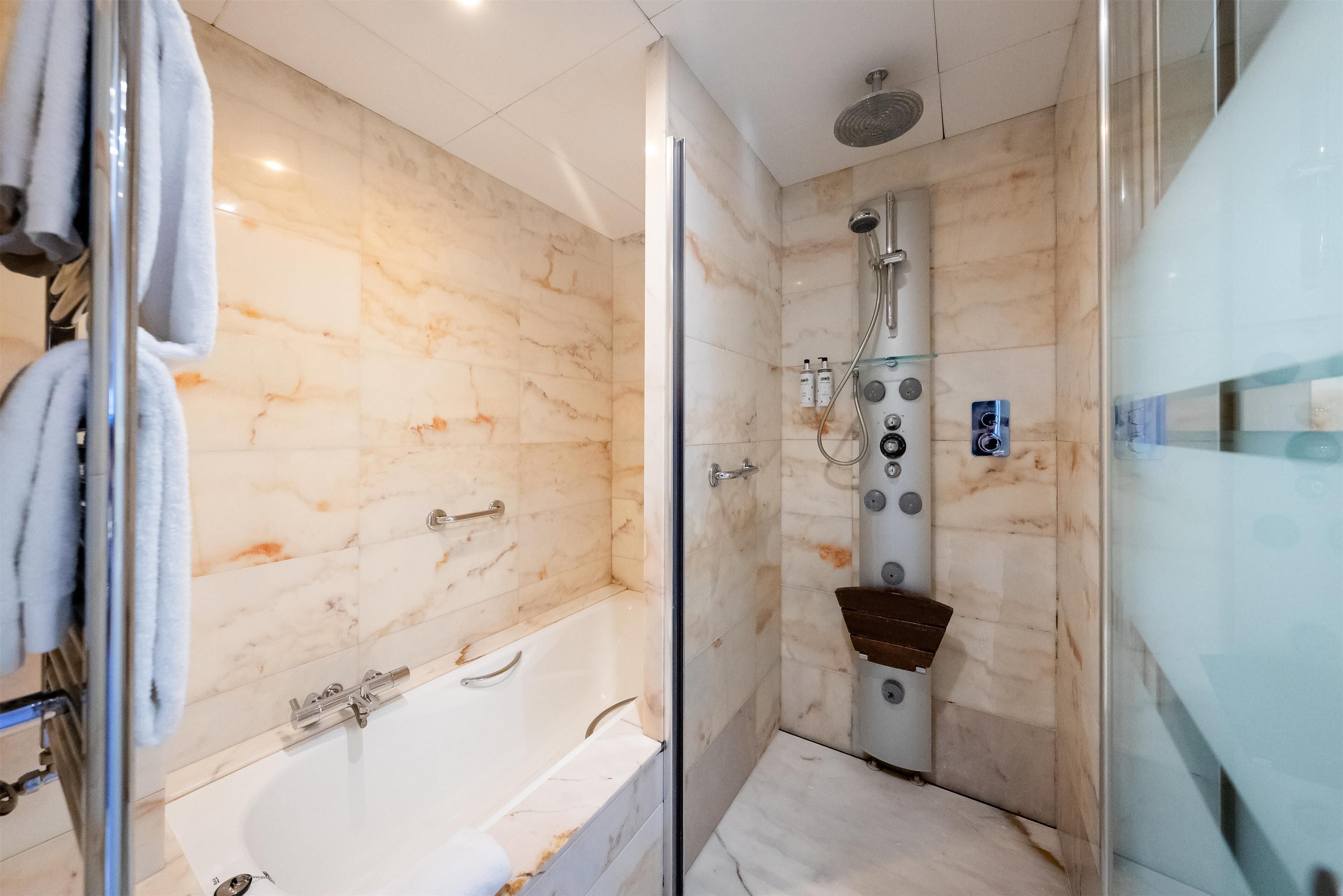 junior suite, 1 king bed, non smoking (living room) | bathroom | combined shower/bathtub, designer toiletries, hair dryer, bidet