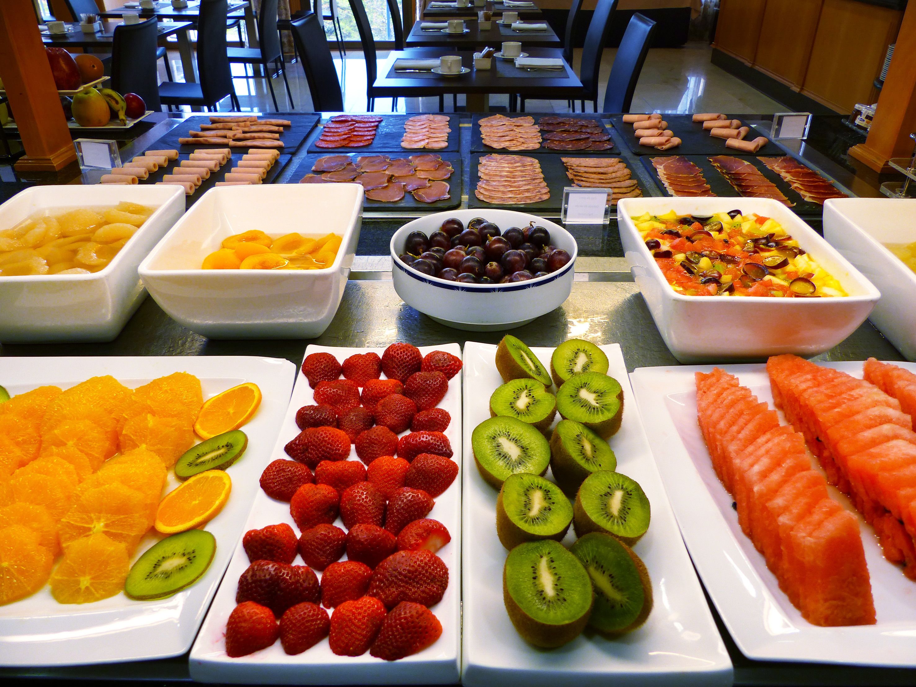 Un bufé con diversas frutas, verduras y carnes.