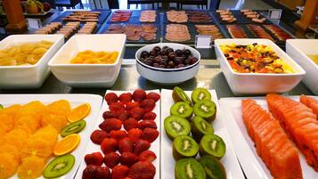 A buffet with various fruits, vegetables, and meats.