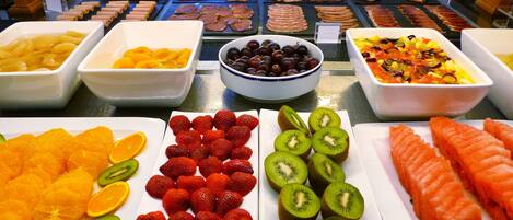 Un bufé con diversas frutas, verduras y carnes.