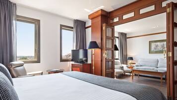 Een hotelkamer met een groot bed, een televisie, een sofa en een bureau.
