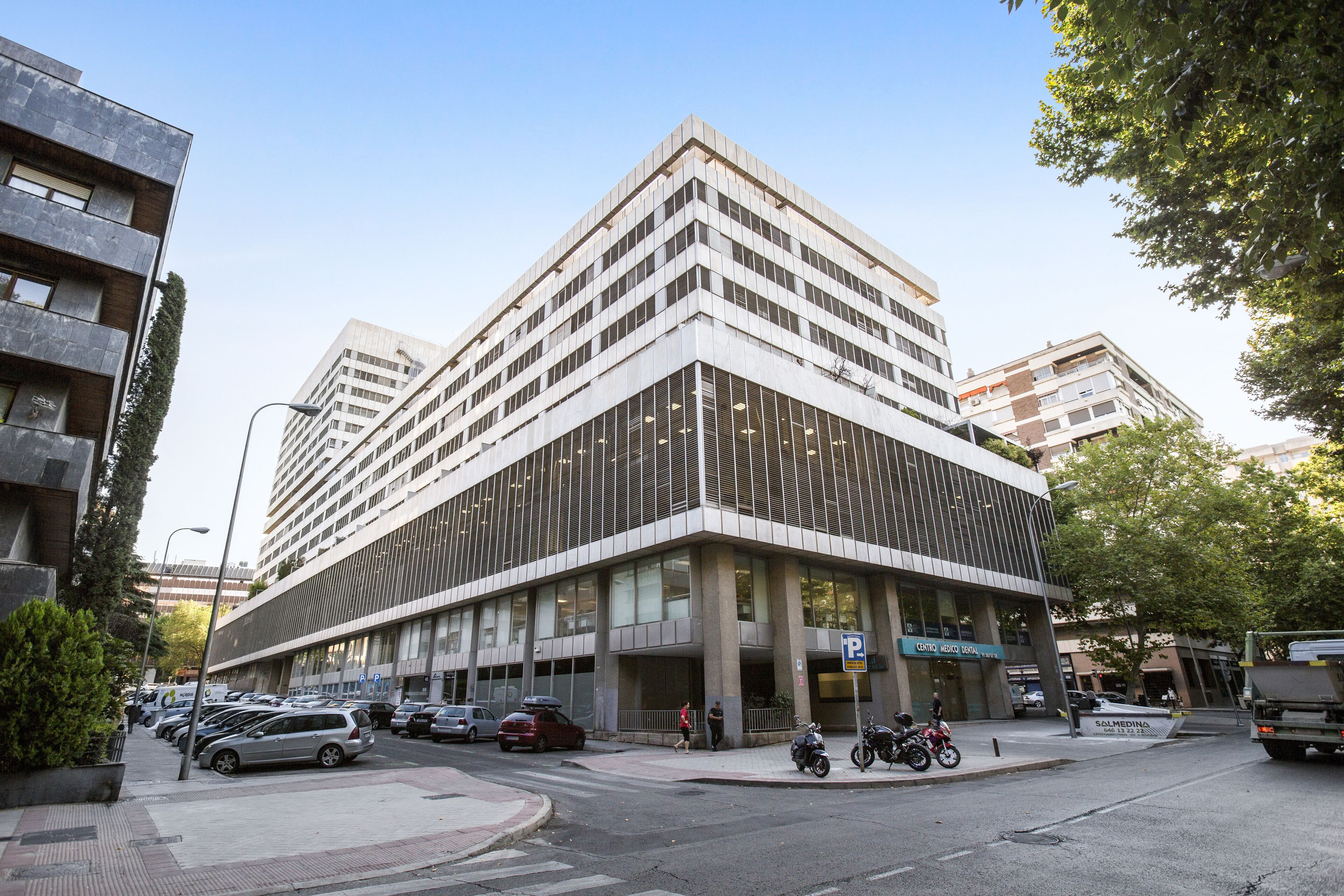 Un edificio moderno con garaje, un acceso cubierto y un letrero que indica Centro de Innovación.