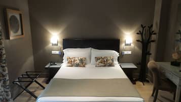 Una camera d'albergo con un letto grande, due comodini, una scrivania e una sedia.