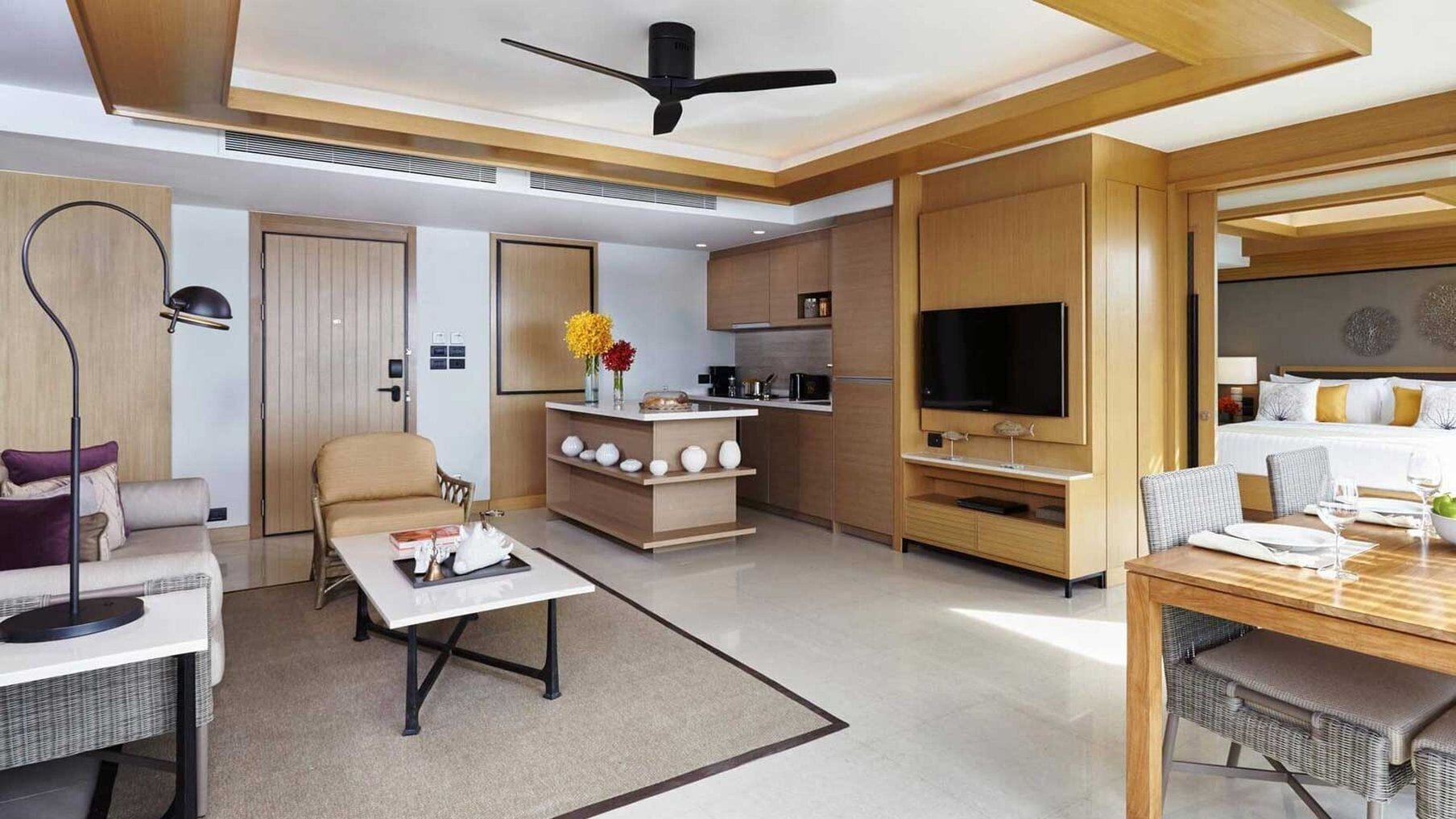 Una habitación de hotel moderna con comedor, kitchenette y televisor.