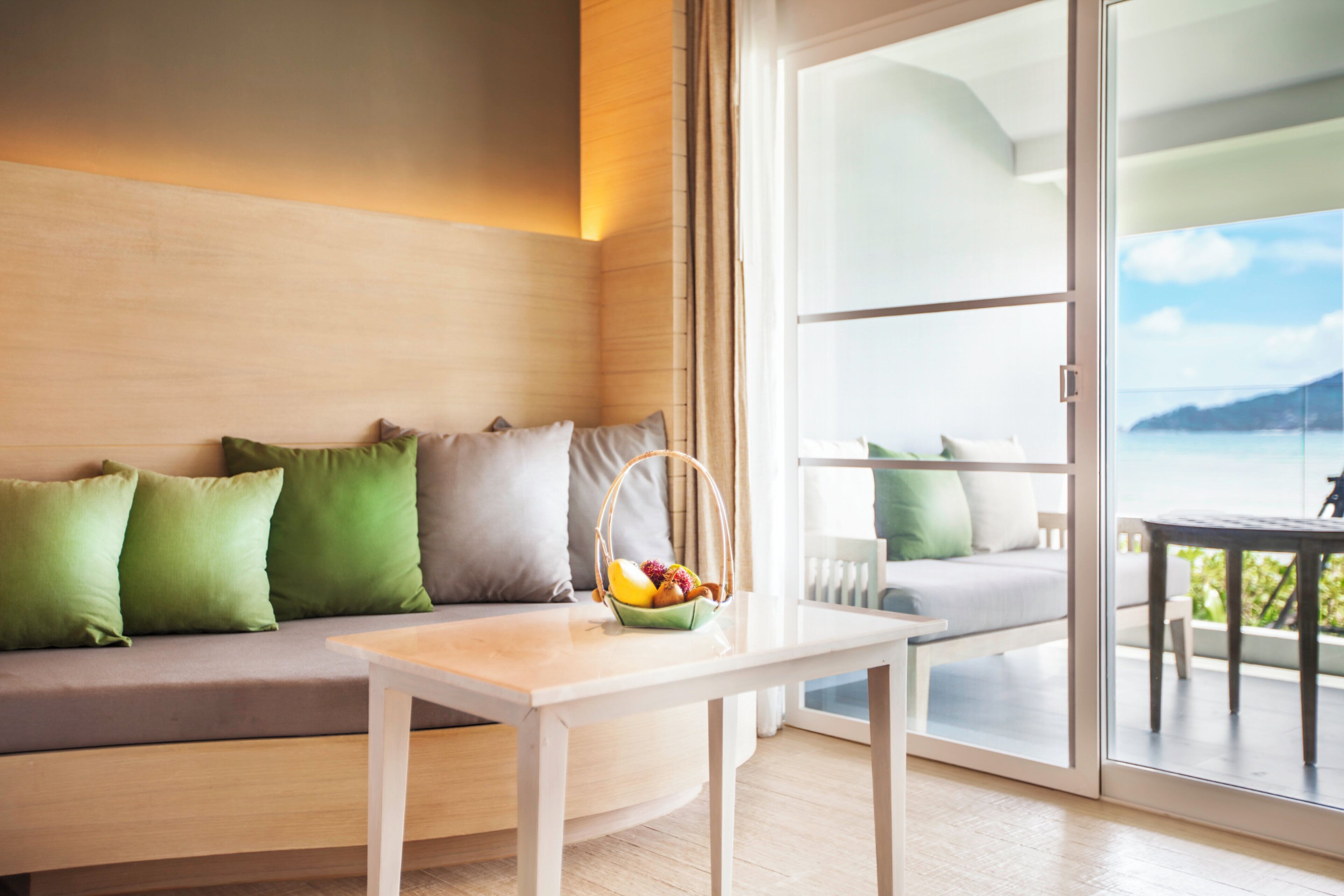 Una habitación moderna con un sofá, una mesa y una cesta de fruta.