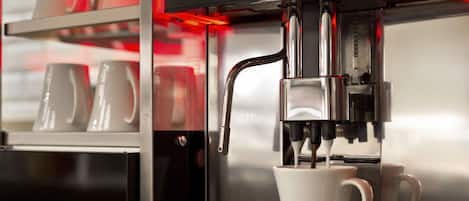 Una máquina de café con pantalla digital y una taza de café sirviéndose.