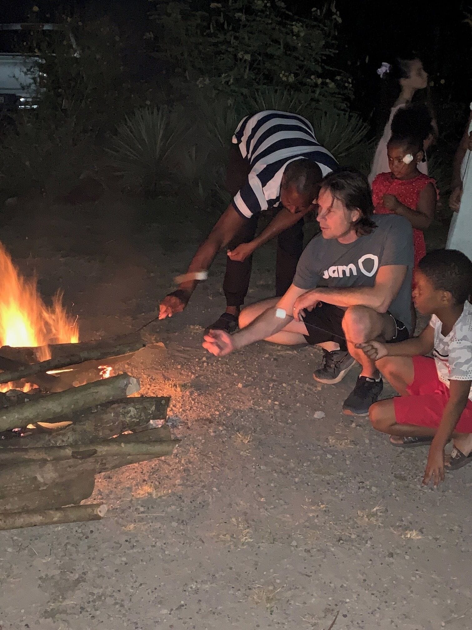 A group of people around a campfire at night.
