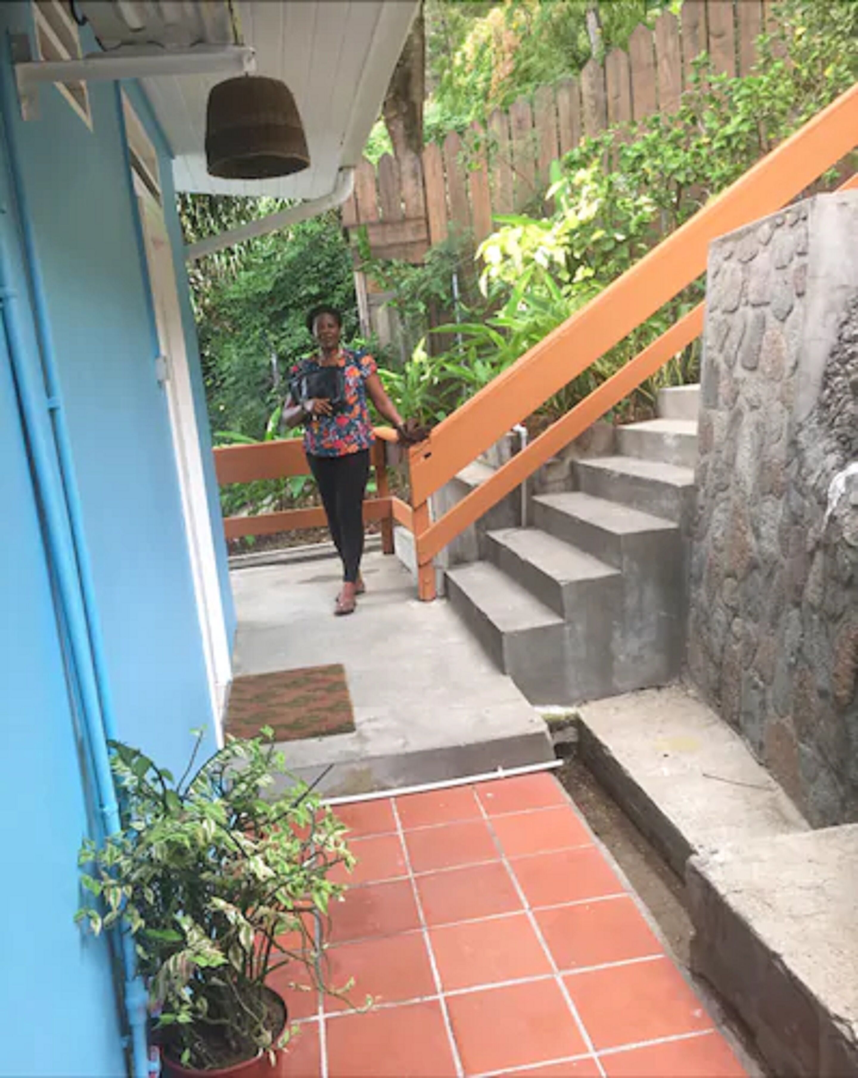 A staircase with a stone wall and a blue door.