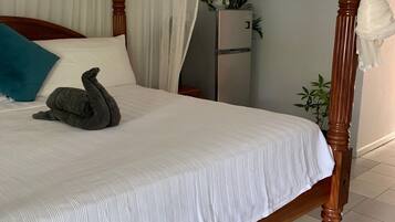 A bed with a canopy, a blue pillow, and a decorative swan.