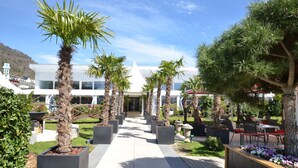 Un sendero que lleva a un edificio moderno con fachada blanca y techo triangular.