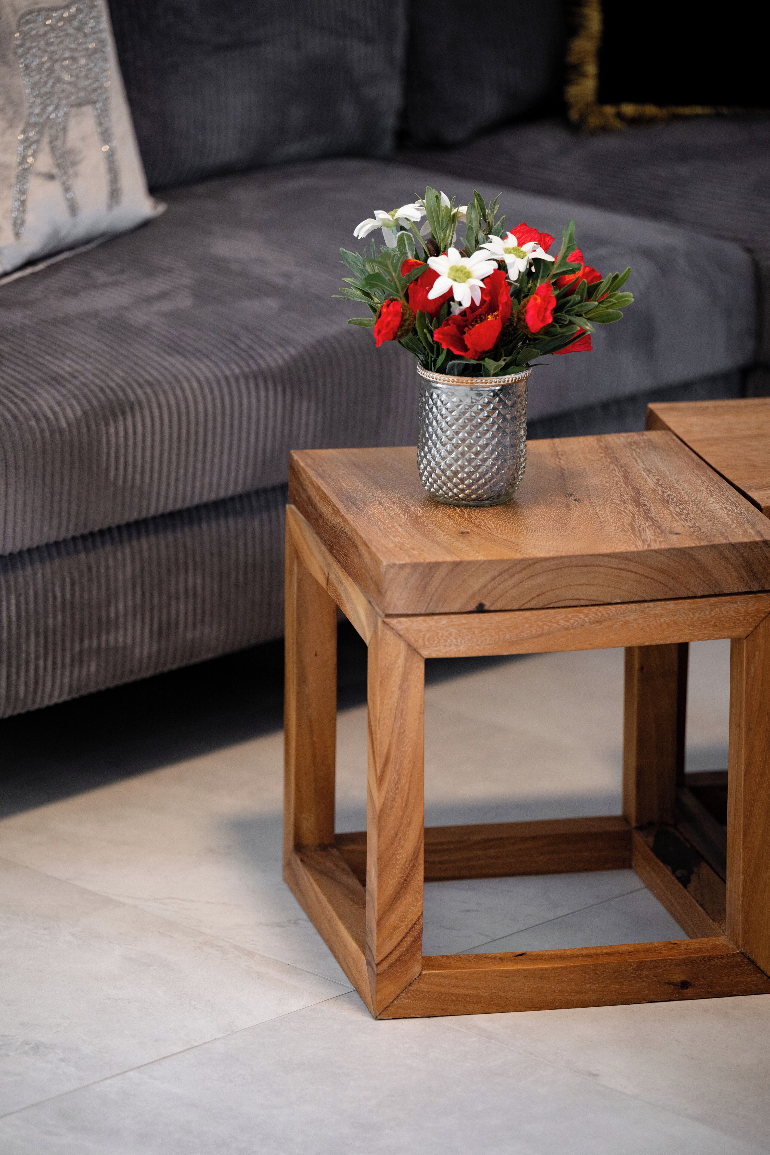 Una mesa de centro de madera con un florero encima.