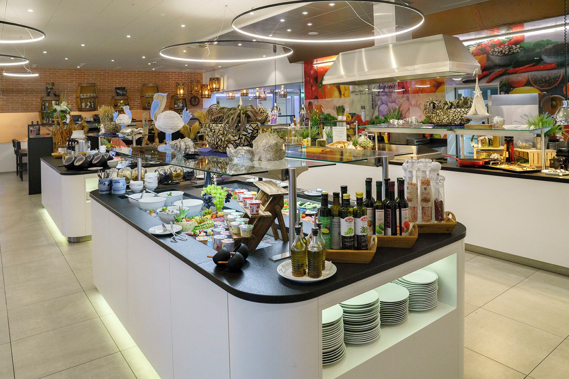 Zona de bufé con diferentes opciones de comida, salsas y una variedad de bebidas.
