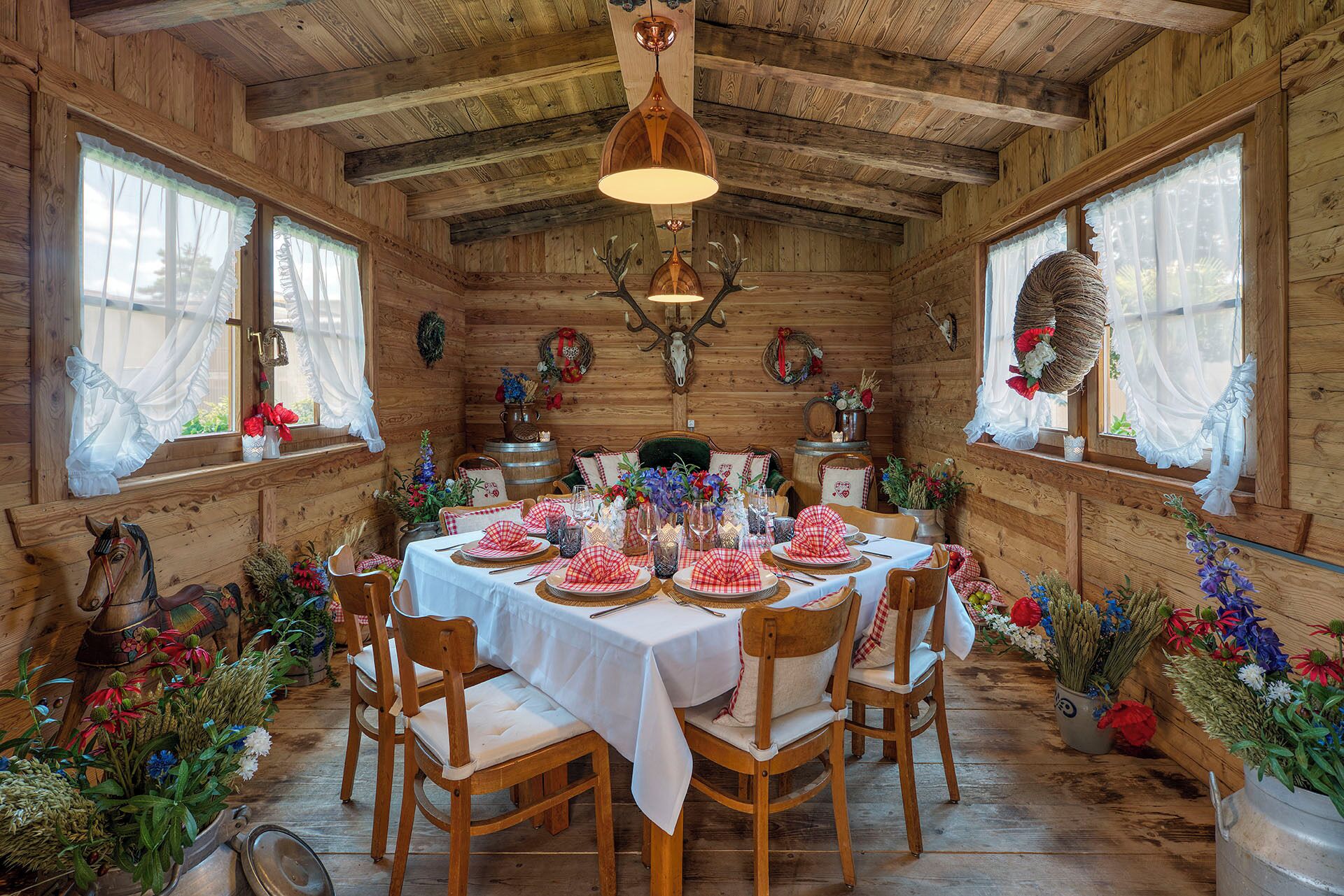 Comedor de madera con una mesa dispuesta para seis personas, rodeada de sillas.