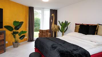 Une chambre à coucher avec un lit, une chaise, une plante en pot et une statue de girafe.