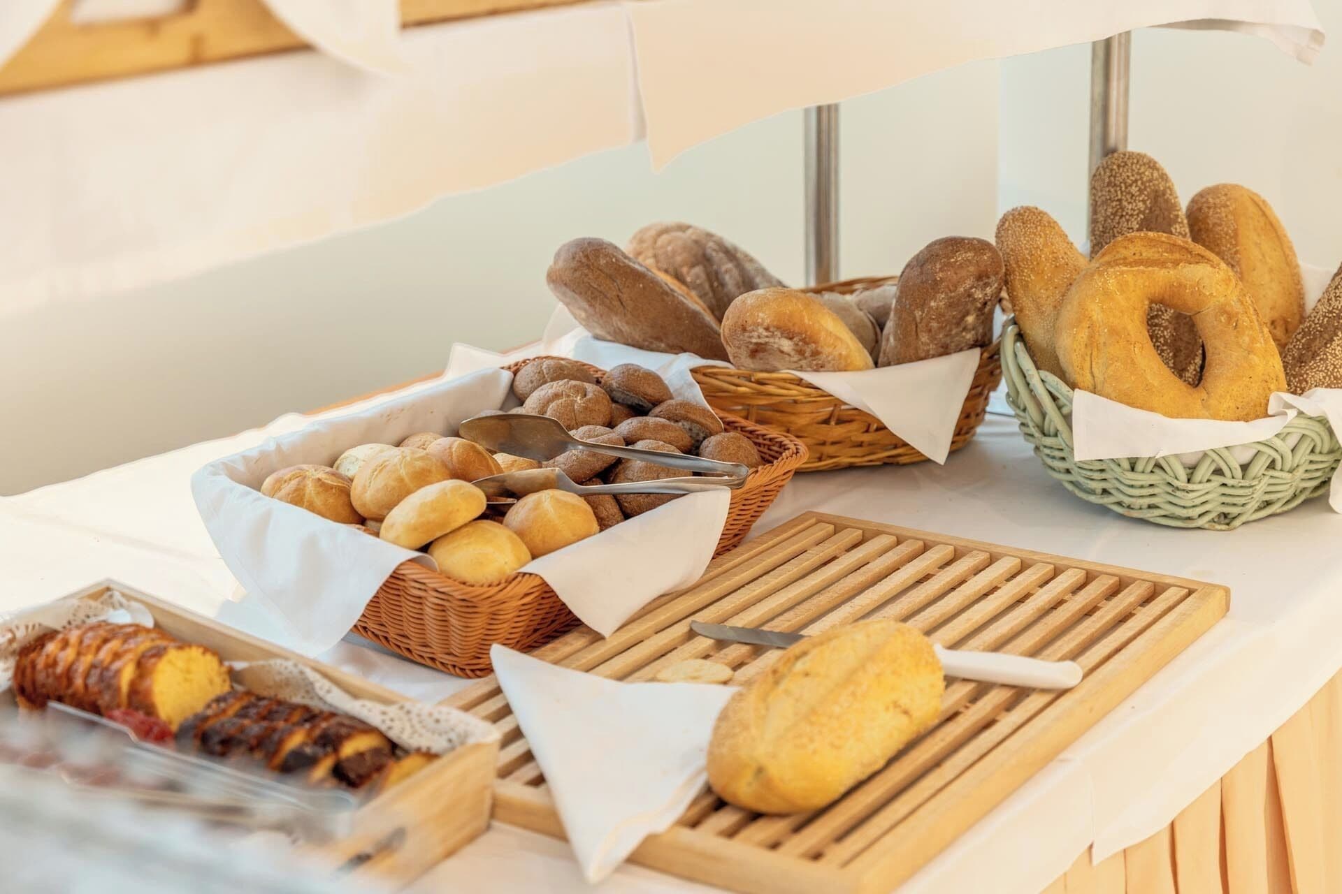 A buffet table with various breads and pastries.