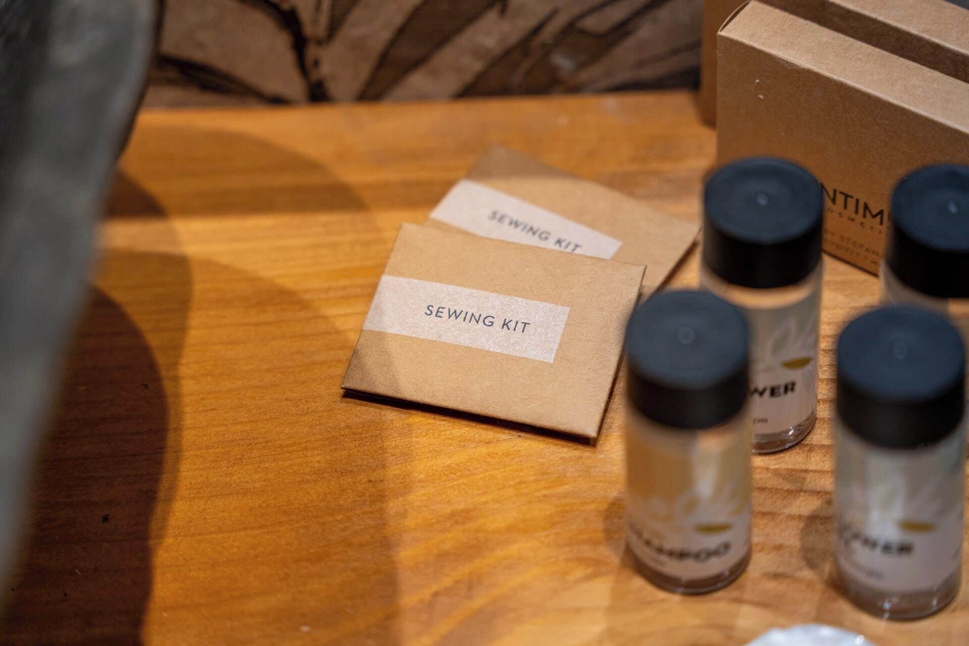 A wooden table with a sewing kit box, two bottles labeled "POWER," and a cardboard box in the background.