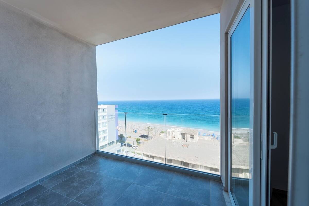 A balcony with a clear view of the beach and ocean.