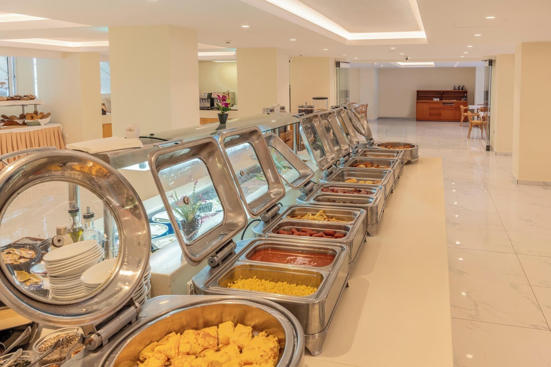 Tarjolla on runsas buffet, jossa on useita ruokapisteitä ja jossa on pitkälle riviin järjestettynä monenlaisia lämpimiä ja kylmiä ruokia.