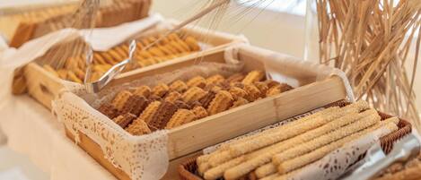 Diversa variedad de panes y pasteles expuestos en cestas de madera sobre una mesa.