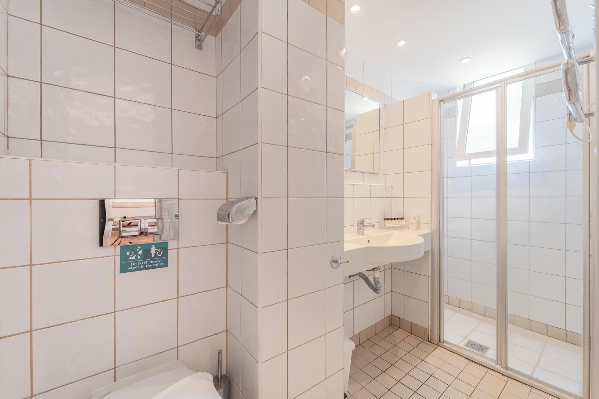 Un baño moderno con inodoro, lavabo y ducha.