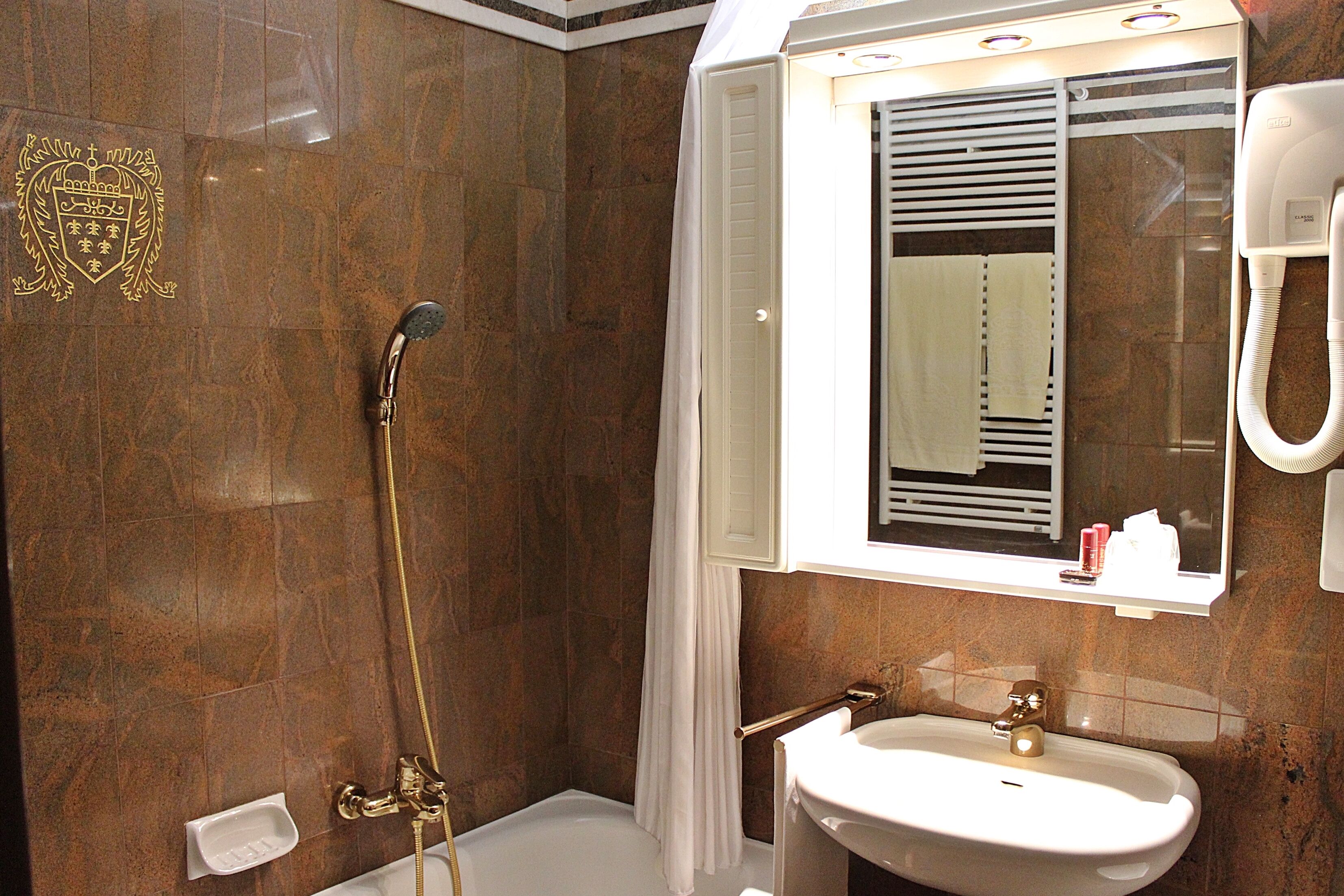 Un baño con ducha, lavamanos y espejo.