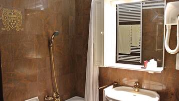 Un baño con ducha, lavamanos y espejo.
