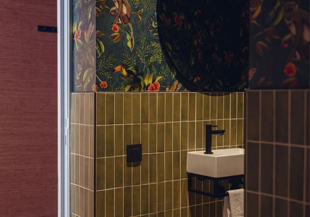A bathroom with a sink, a mirror, and a towel rack.