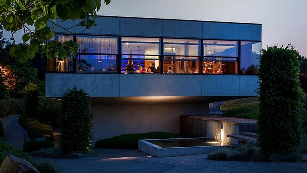 Un edificio moderno con ventanas amplias y una zona de piscina.