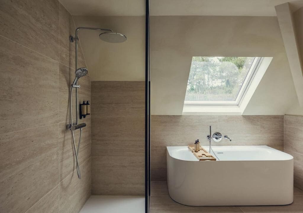 A modern bathroom with a walk-in shower, a freestanding bathtub, and a skylight.