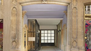 The entrance of the Mercure Hotel with a grand archway, large windows, and a clear view into the interior. - Mercure Grand Hotel Metz Centre Cathédrale (Metz)
