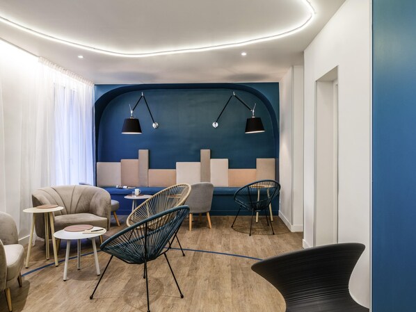 A modern lounge area with seating, a blue accent wall, and pendant lighting. - ibis Styles Asnières Centre (Asnieres-sur-Seine)