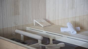 A wooden sauna with a bench, a towel, and a wooden wall.