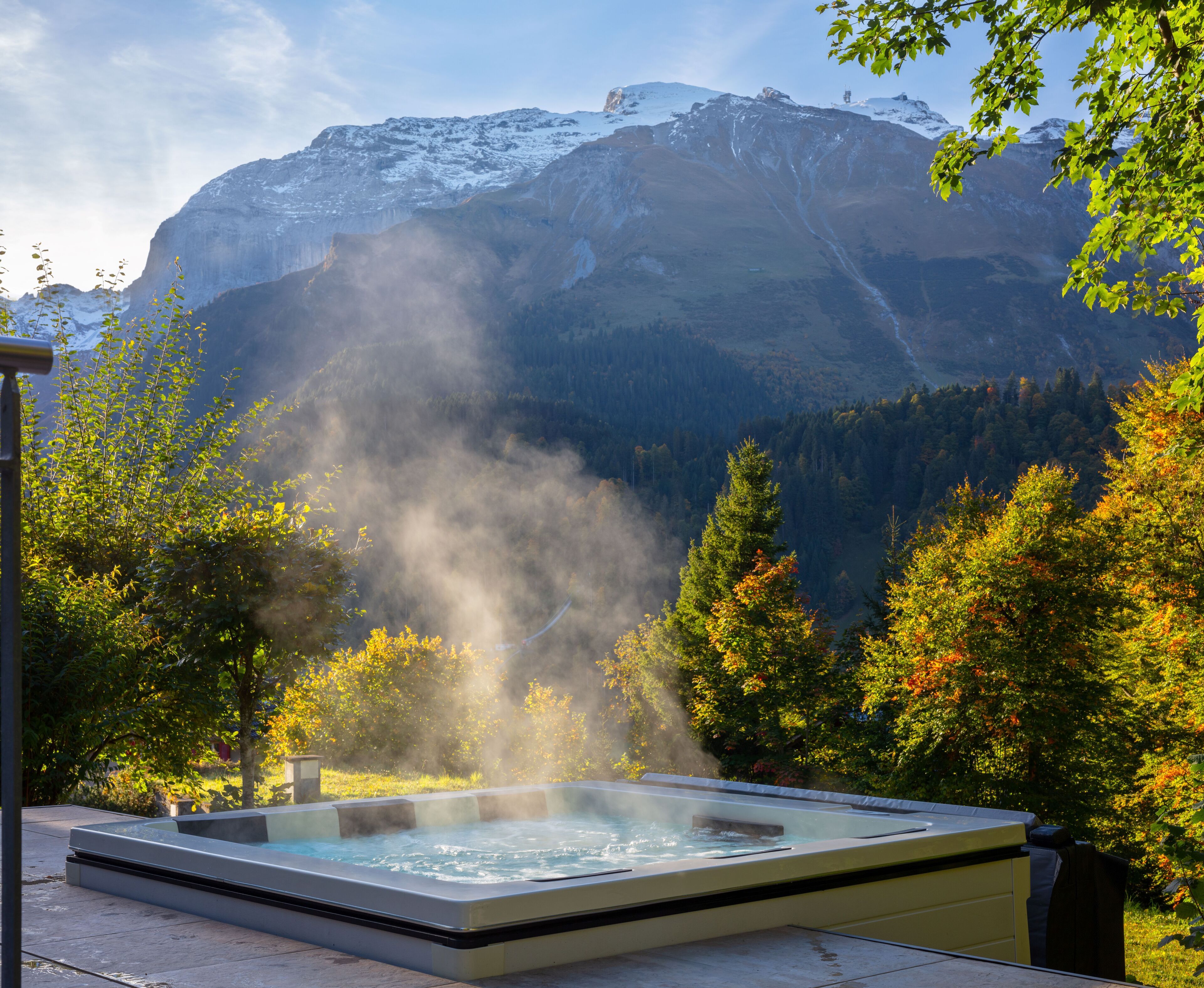 Un bain à remous entouré d’arbres et de montagnes.