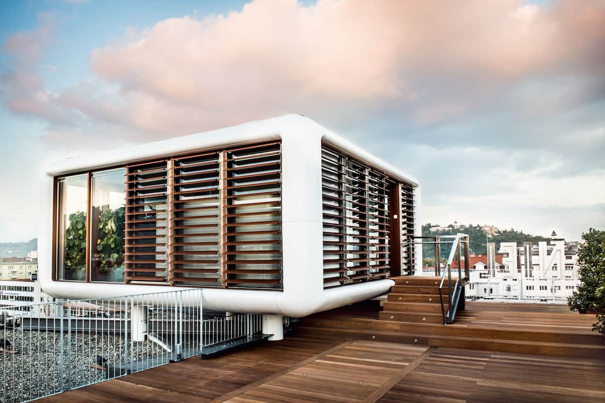 A modern building with large windows and a wooden deck.