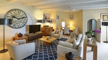 Una sala de estar moderna con un reloj de pared grande, sofás, una mesa de centro y un televisor.
