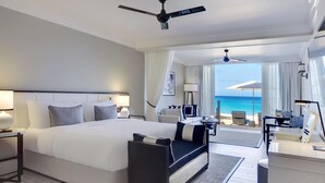 A modern hotel room with a large bed, a sofa, a desk, and a view of the ocean. - Fairmont Royal Pavilion (Holetown)