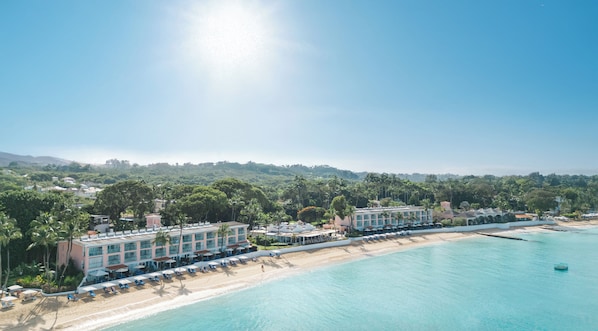 A beachfront hotel with multiple buildings, a sandy beach, and a clear blue sea. - Fairmont Royal Pavilion (Holetown)